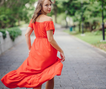 Lange zalmkleurige jurk gedragen door een vrouw buiten