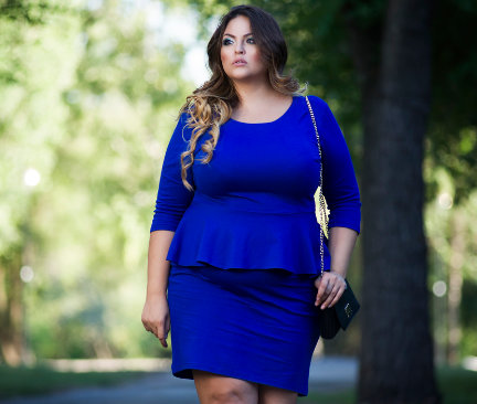 Blauwe jurk in grote maat gedragen door een vrouw buiten