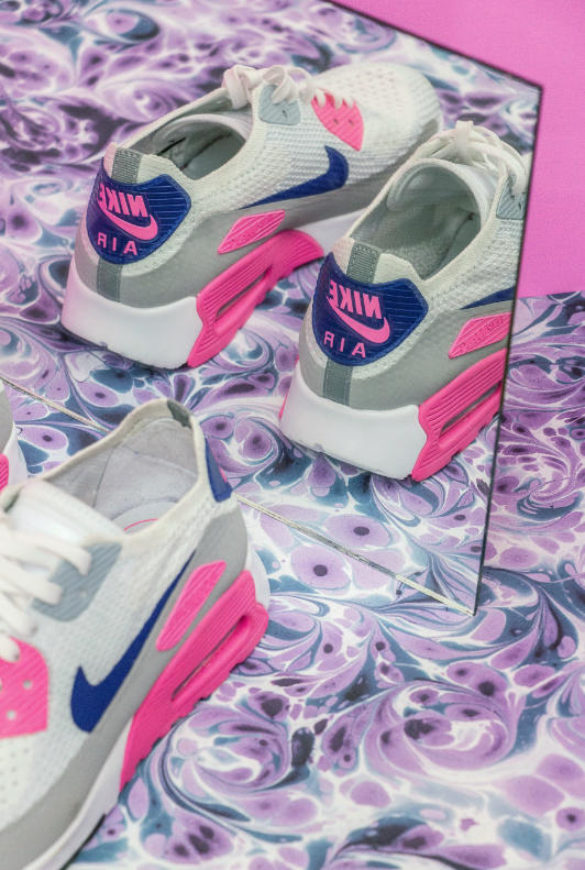 Roze met blauwe Nike sneakers in spiegelbeeld