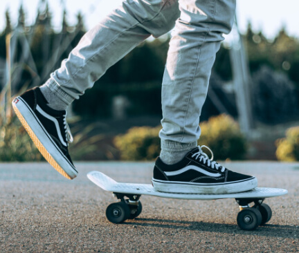 Zwarte Vans schoenen op een skateboard