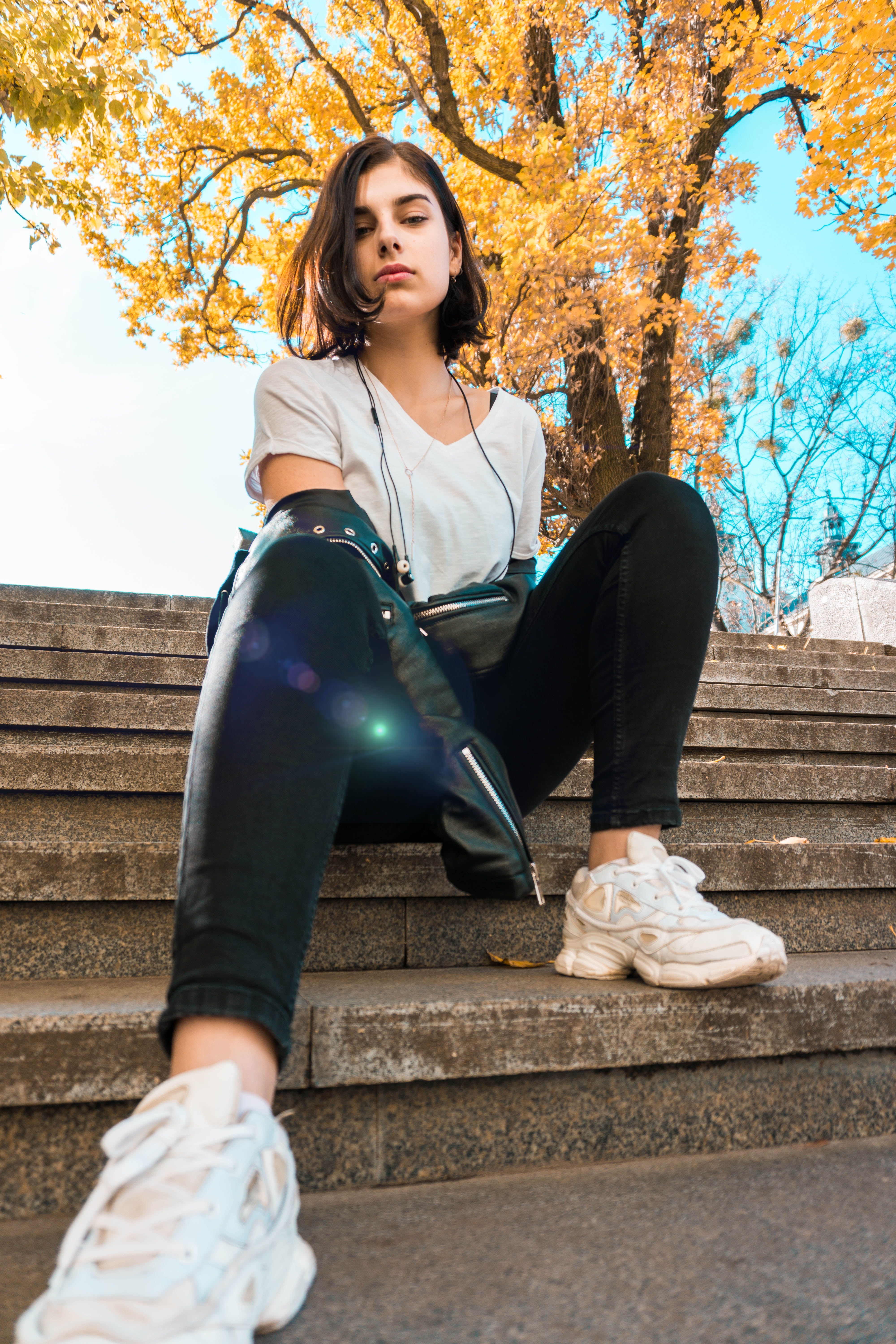 Sneakertrends 2020: Jonge vrouw met sneakers op een betonnen trap in de herfst
